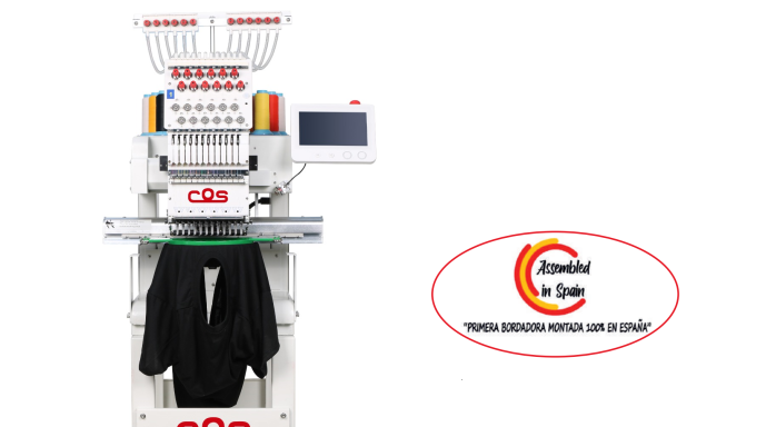 Máquina de bordar con pantalla y ropa oscura colgada, junto a un logo.